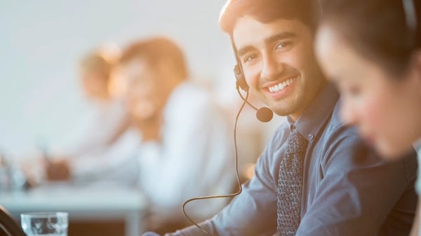 Man smiling with headset in office