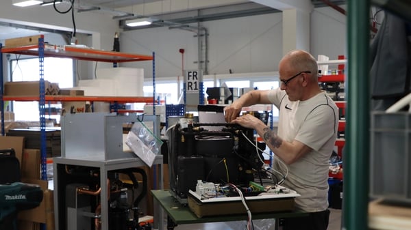 A man works on a machine in the Kensa Heat Pumps factory.